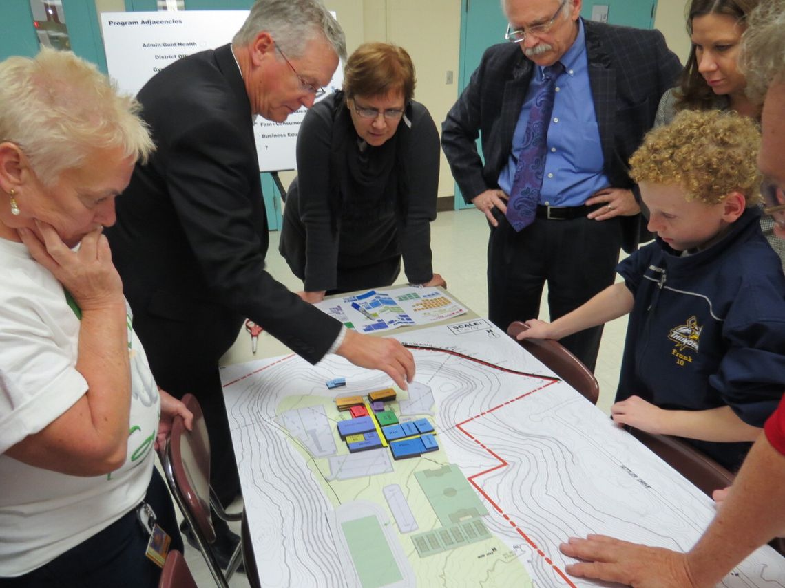 Adults and a child reviewing blueprints