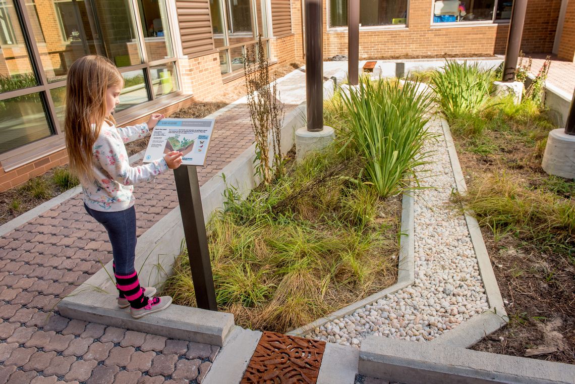 Child reading a plaque